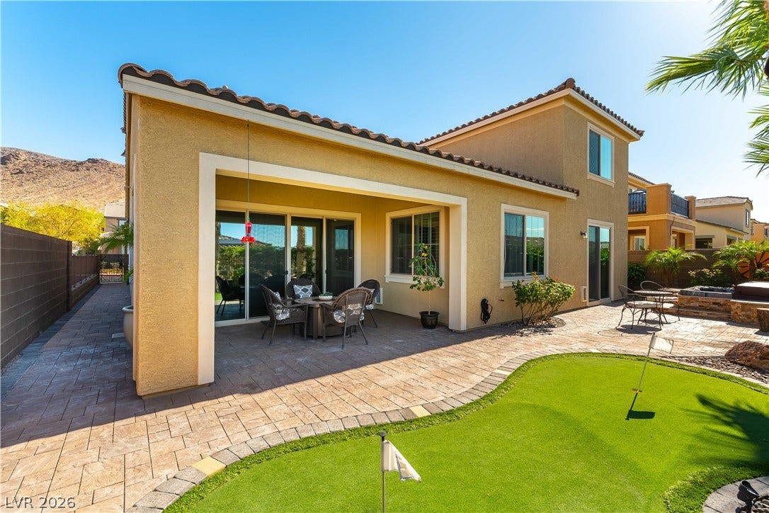 900 San Laurent Court, Henderson, NV 89012 A private backyard oasis features a covered patio, paved walkways, and a putting green.