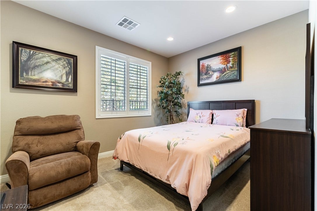 900 San Laurent Court, Henderson, NV 89012 Recessed lighting and ample natural light define this cozy bedroom retreat.