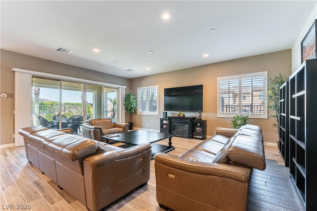 900 San Laurent Court, Henderson, NV 89012 Recessed lighting illuminates this inviting family room, featuring sliding glass doors and light wood flooring.
