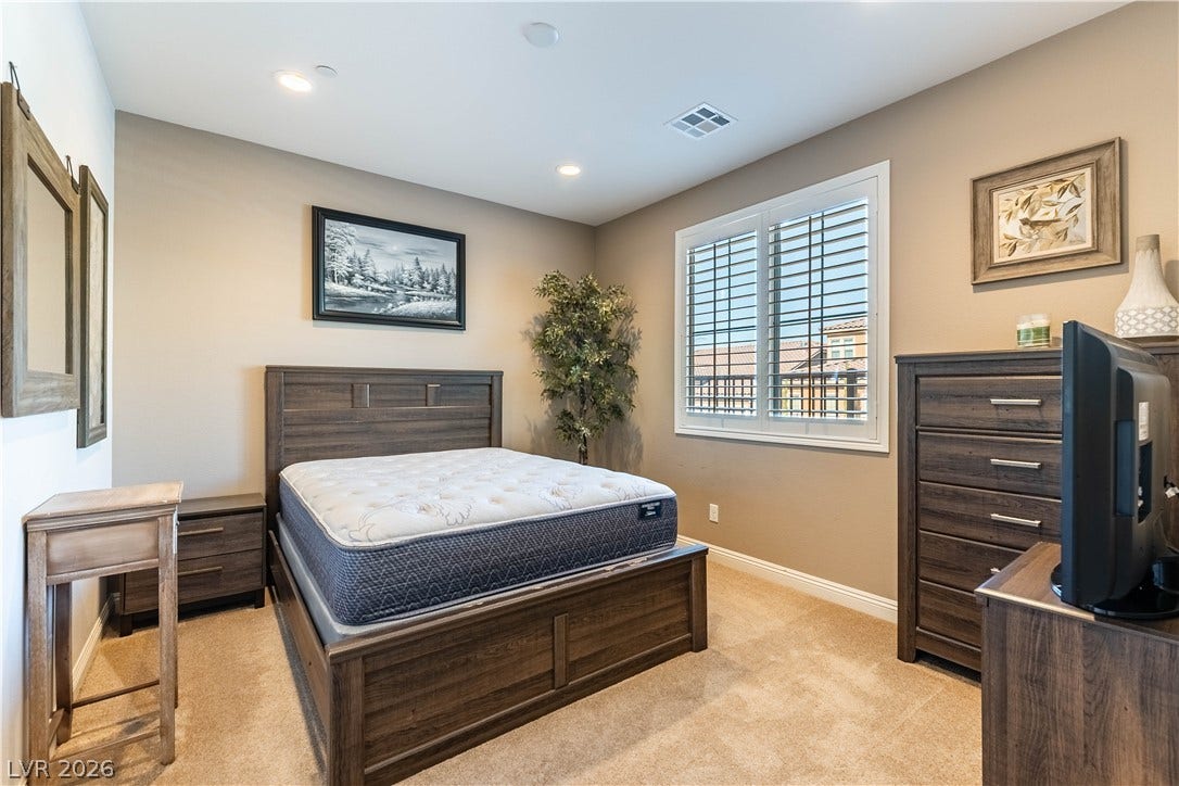 900 San Laurent Court, Henderson, NV 89012 Natural light filters through louvered windows into this inviting, well-lit bedroom.