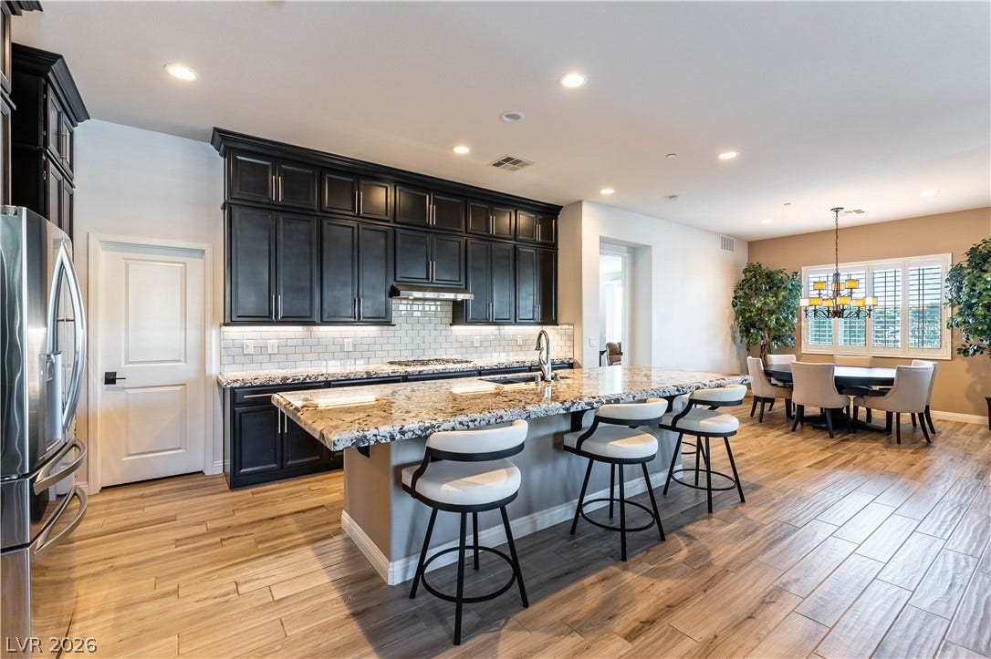 900 San Laurent Court, Henderson, NV 89012 An inviting open-concept kitchen and dining area features rich cabinetry and polished flooring.