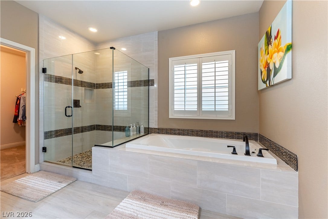 900 San Laurent Court, Henderson, NV 89012 Indulge in a primary bathroom designed for relaxation with a spacious soaking tub and a glass-enclosed shower.