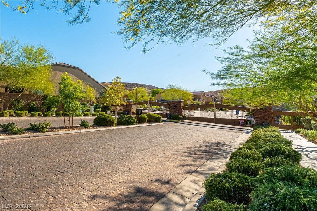 900 San Laurent Court, Henderson, NV 89012 Secure community entrance with an inviting paved drive, surrounded by natural landscaping.