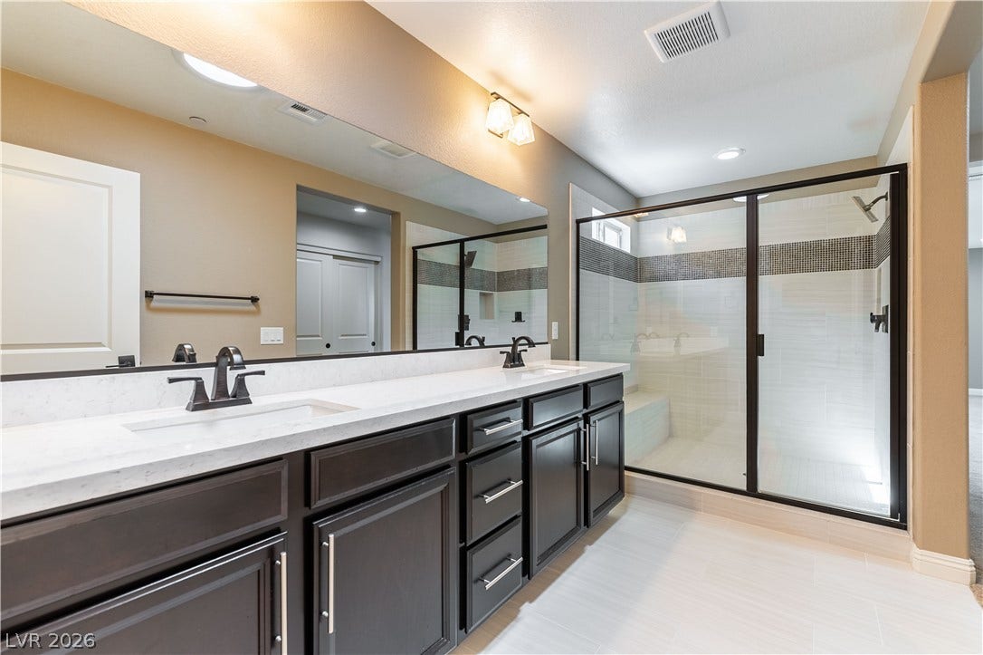 900 San Laurent Court, Henderson, NV 89012 Dual vanity with pristine countertops and a glass-enclosed shower create a tranquil retreat.