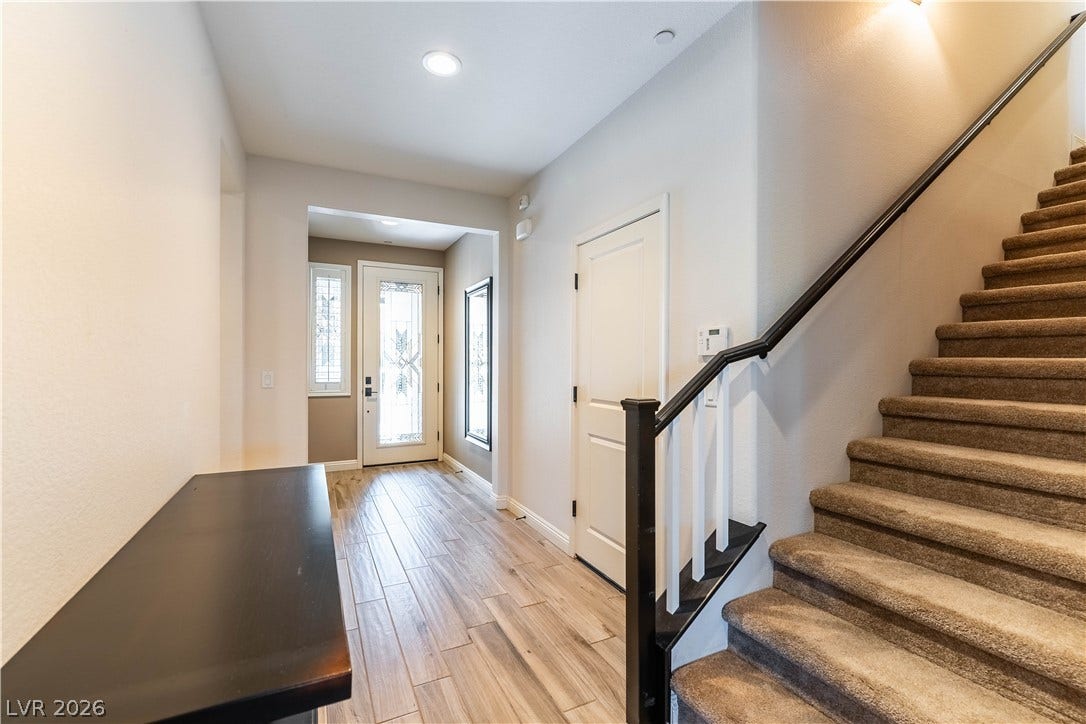 900 San Laurent Court, Henderson, NV 89012 A welcoming entry features bright recessed lighting and warm wood-look flooring leading to carpeted stairs.