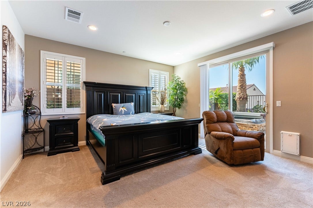 900 San Laurent Court, Henderson, NV 89012 Natural light bathes this comfortable bedroom, featuring plush carpet and direct outdoor access.