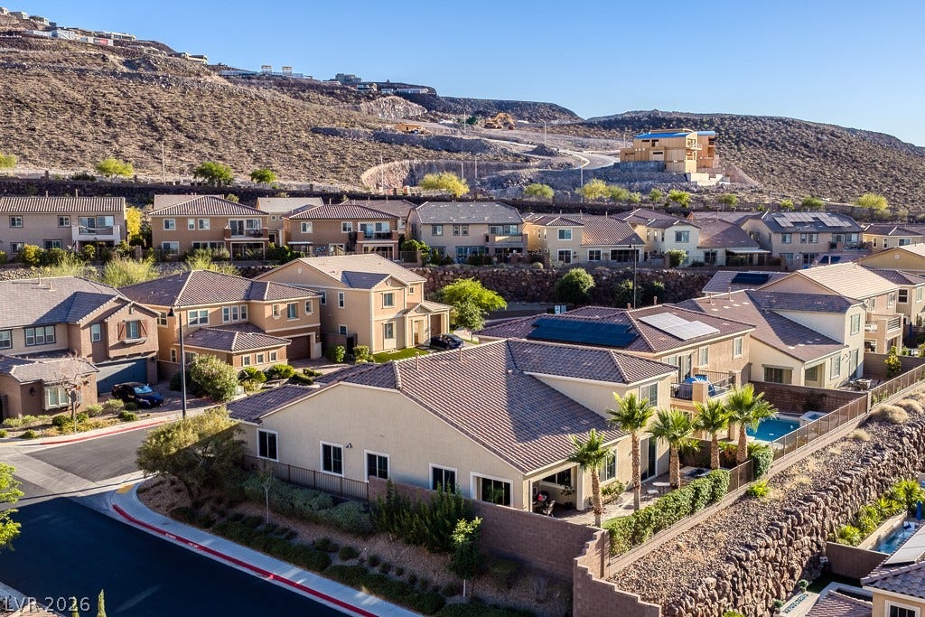 900 San Laurent Court, Henderson, NV 89012 An aerial perspective reveals a hillside community with diverse home designs and vibrant landscaping.
