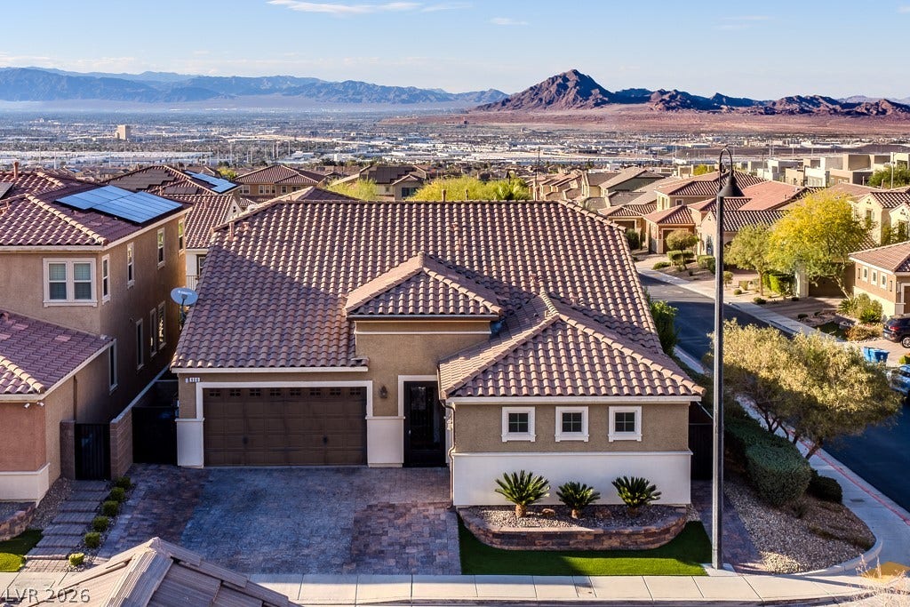 900 San Laurent Court, Henderson, NV 89012 Desert foothills backdrop frames this Mediterranean-inspired home with solar panels and a tile roof.