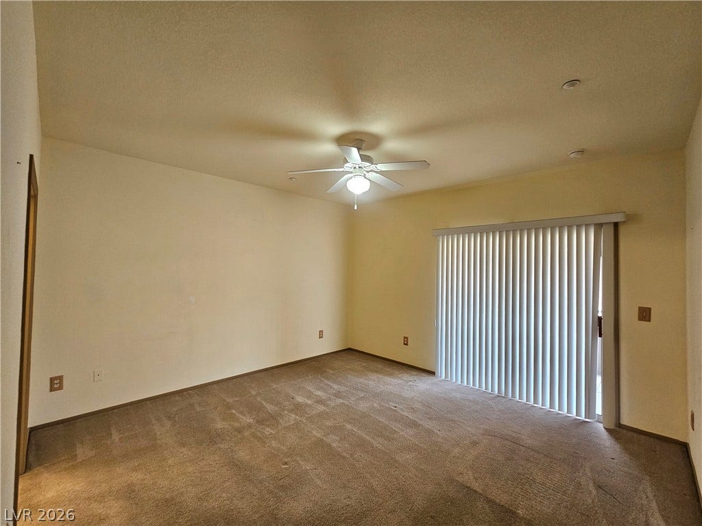 833 Aspen Peak Loop, #112, Henderson, NV 89011 The primary bedroom features a ceiling fan and slider to the patio
