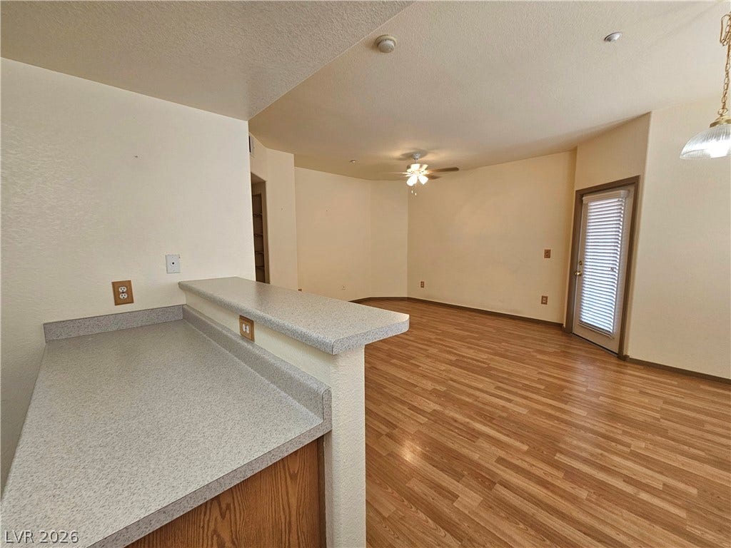 833 Aspen Peak Loop, #112, Henderson, NV 89011 A well-lit living area features practical countertops and lovely wood laminate flooring.