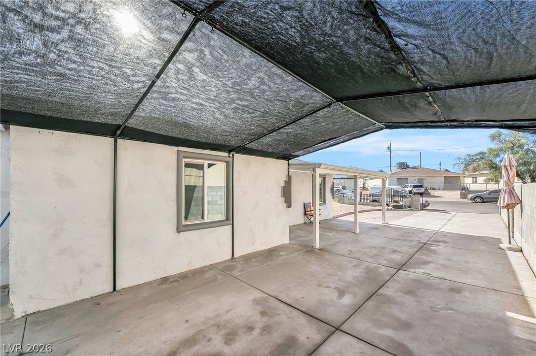 A spacious covered patio provides a shaded outdoor living area, perfect for relaxation or entertaining.