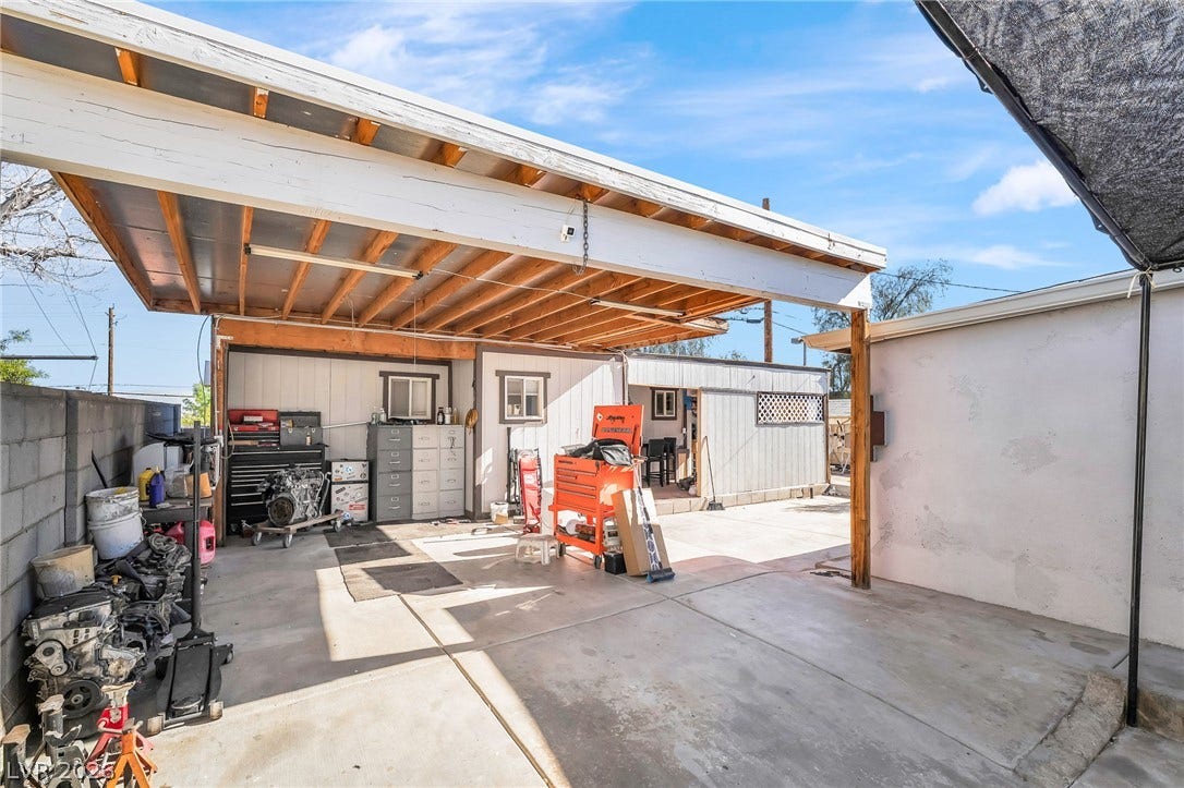 A durable concrete pad provides ample space for projects, sheltered by a practical overhead structure.