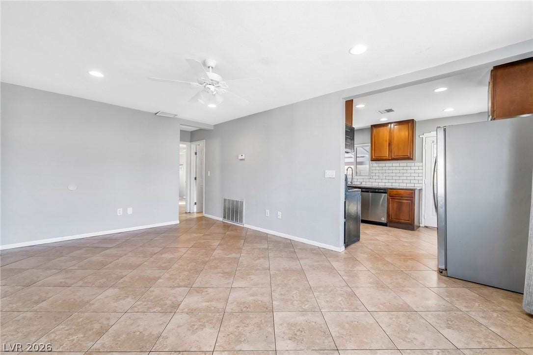A versatile open-concept space featuring tile flooring and a bright kitchen with contemporary appliances.