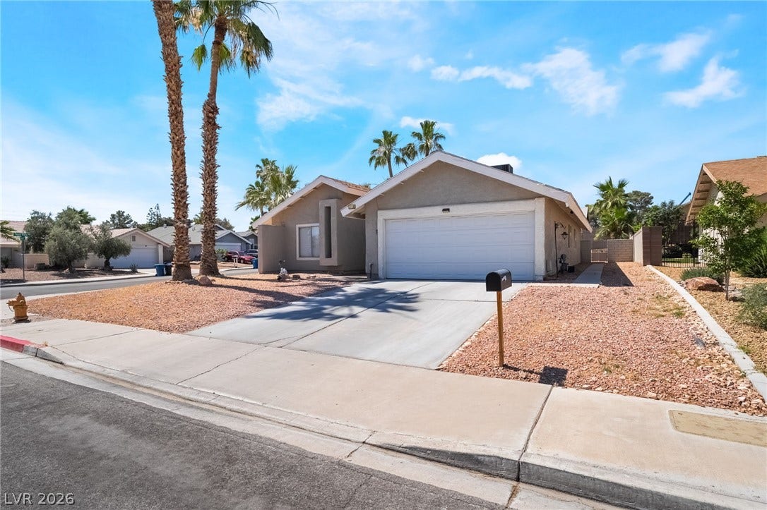 3111 Belvedere Drive, Henderson, NV 89014 A well-maintained suburban home featuring a concrete driveway and xeriscaped front yard with mature palm trees.
