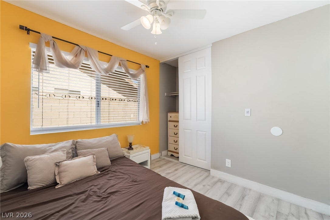 3111 Belvedere Drive, Henderson, NV 89014 A comfortable bedroom with light wood-style flooring and a spacious closet, ideal for restful nights.