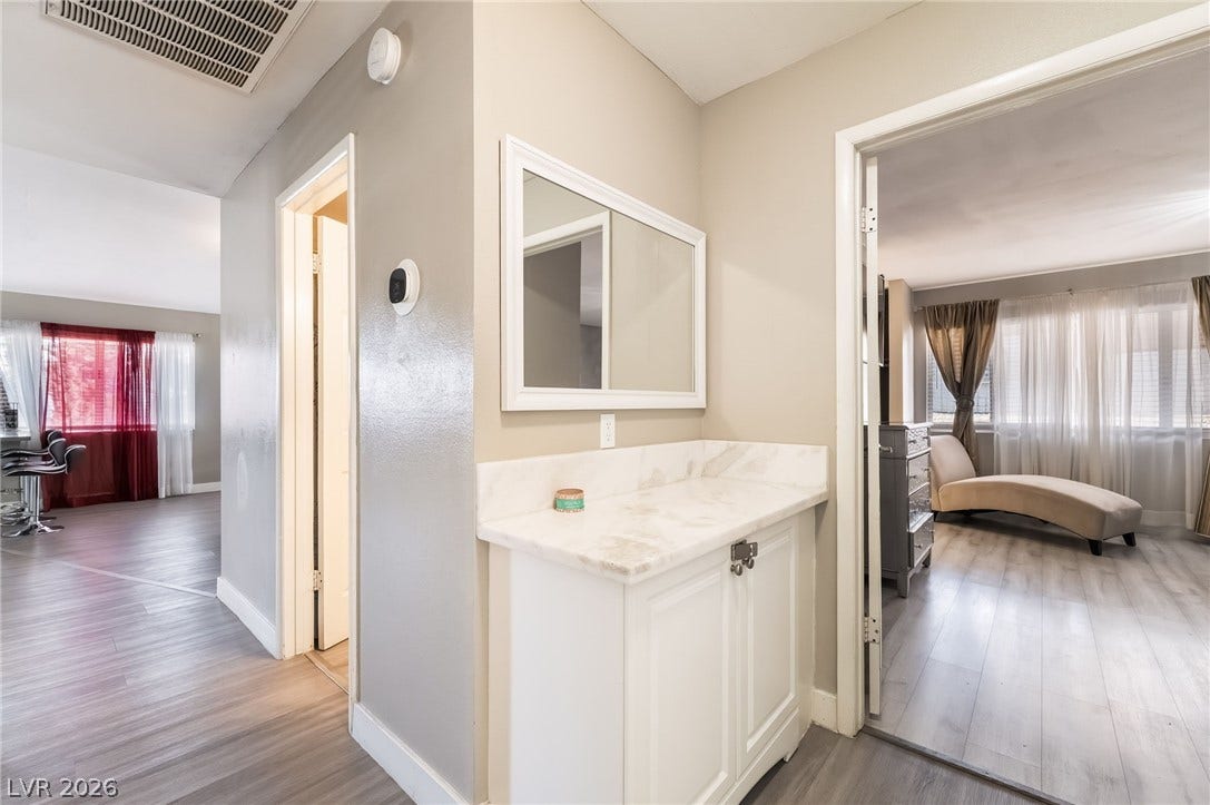 3111 Belvedere Drive, Henderson, NV 89014 A well-lit corridor with sleek wood-look flooring connects various inviting spaces.