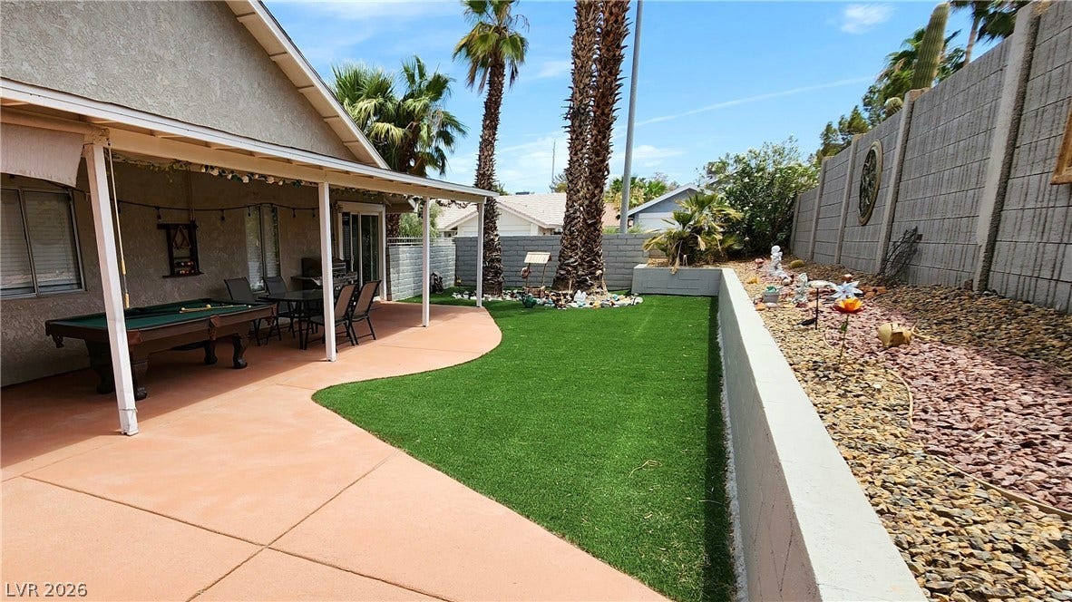 3111 Belvedere Drive, Henderson, NV 89014 A private backyard oasis features a covered patio, artificial turf, and a low-maintenance rock garden.