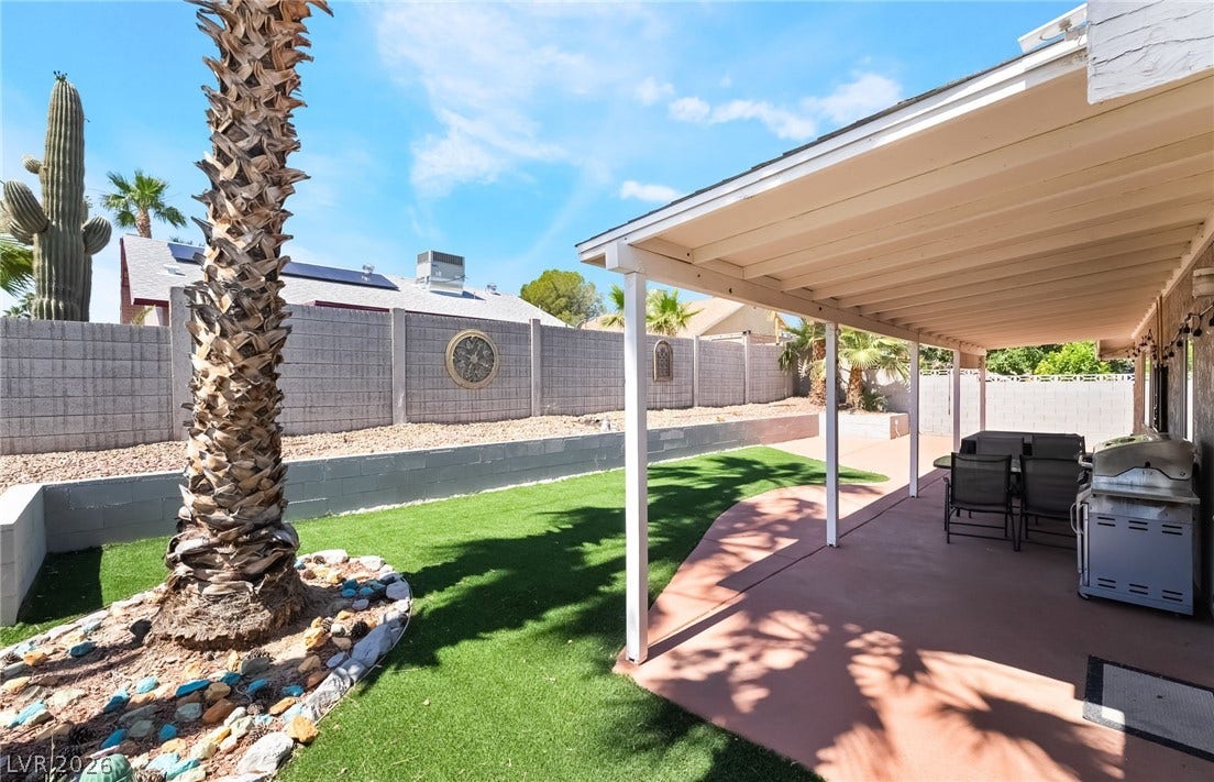 3111 Belvedere Drive, Henderson, NV 89014 An inviting backyard oasis awaits, featuring a covered patio and a maintenance-free turf lawn.