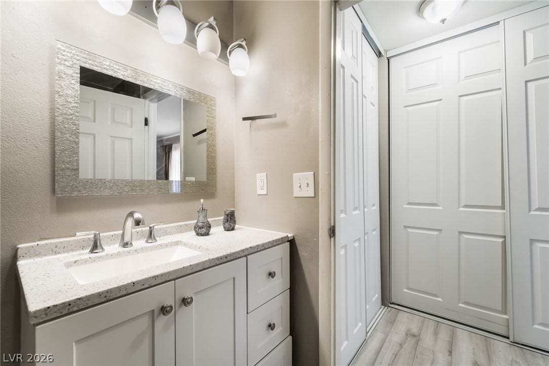 3111 Belvedere Drive, Henderson, NV 89014 A well-lit vanity with a sparkling countertop and stylish cabinetry defines this functional bathroom space.