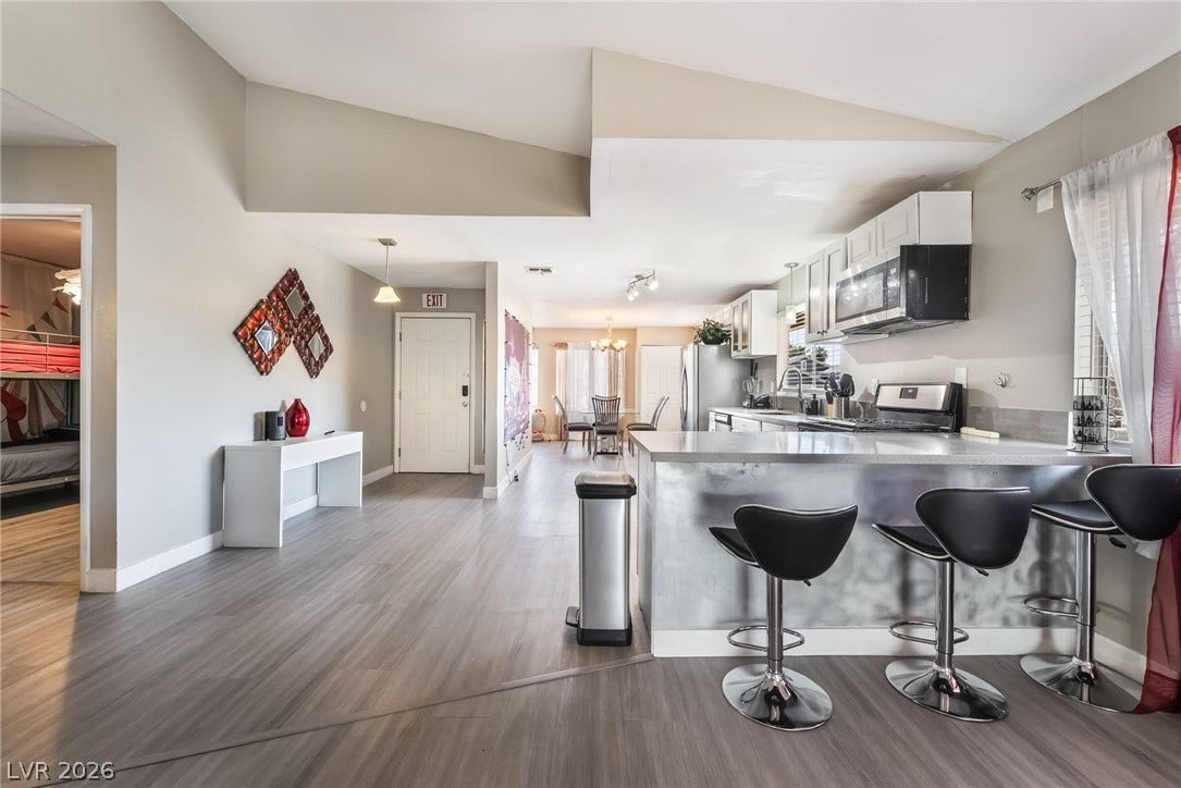3111 Belvedere Drive, Henderson, NV 89014 An open-concept living space integrates a well-appointed kitchen with dining and lounge areas, featuring modern finishes and ample natural illumination.