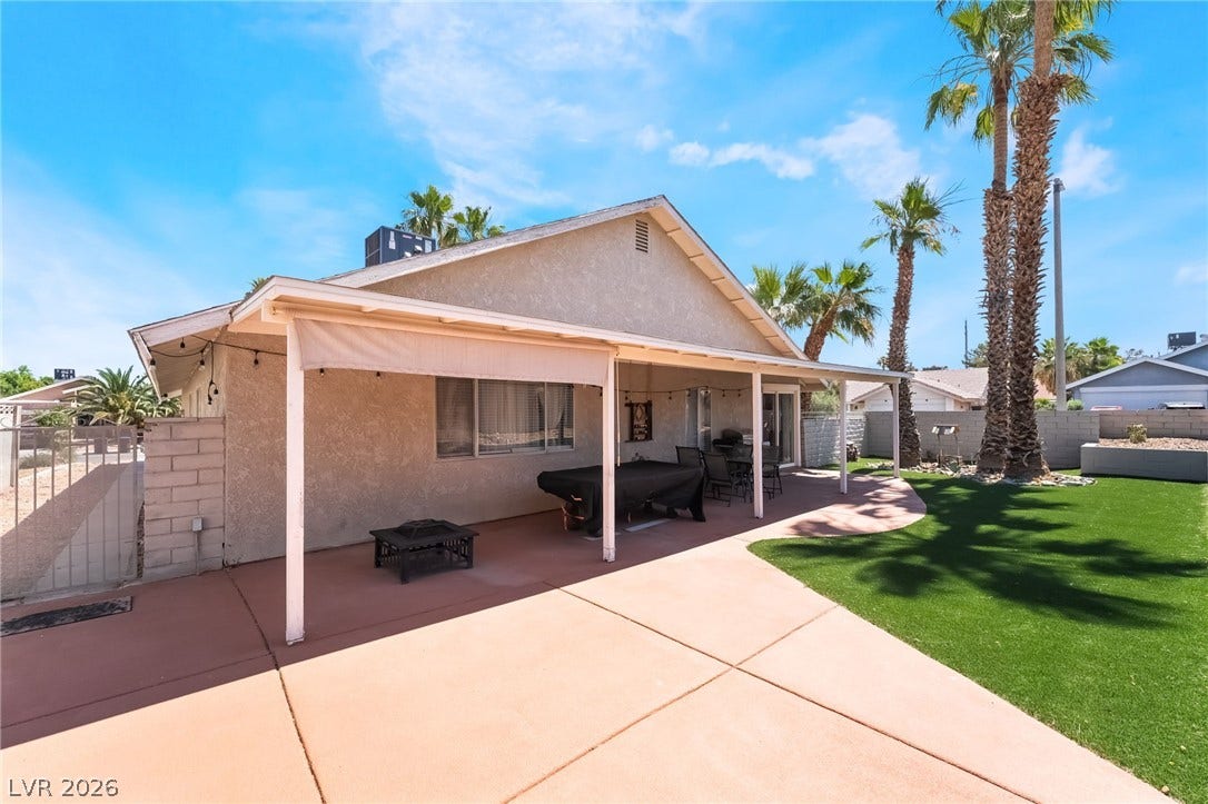 3111 Belvedere Drive, Henderson, NV 89014 A spacious backyard features a covered patio perfect for outdoor enjoyment and lush green landscaping.