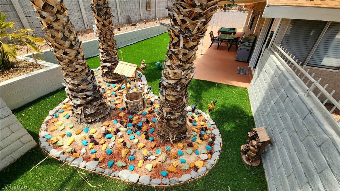 3111 Belvedere Drive, Henderson, NV 89014 A vibrant backyard oasis with an inviting patio space and mature palm trees.