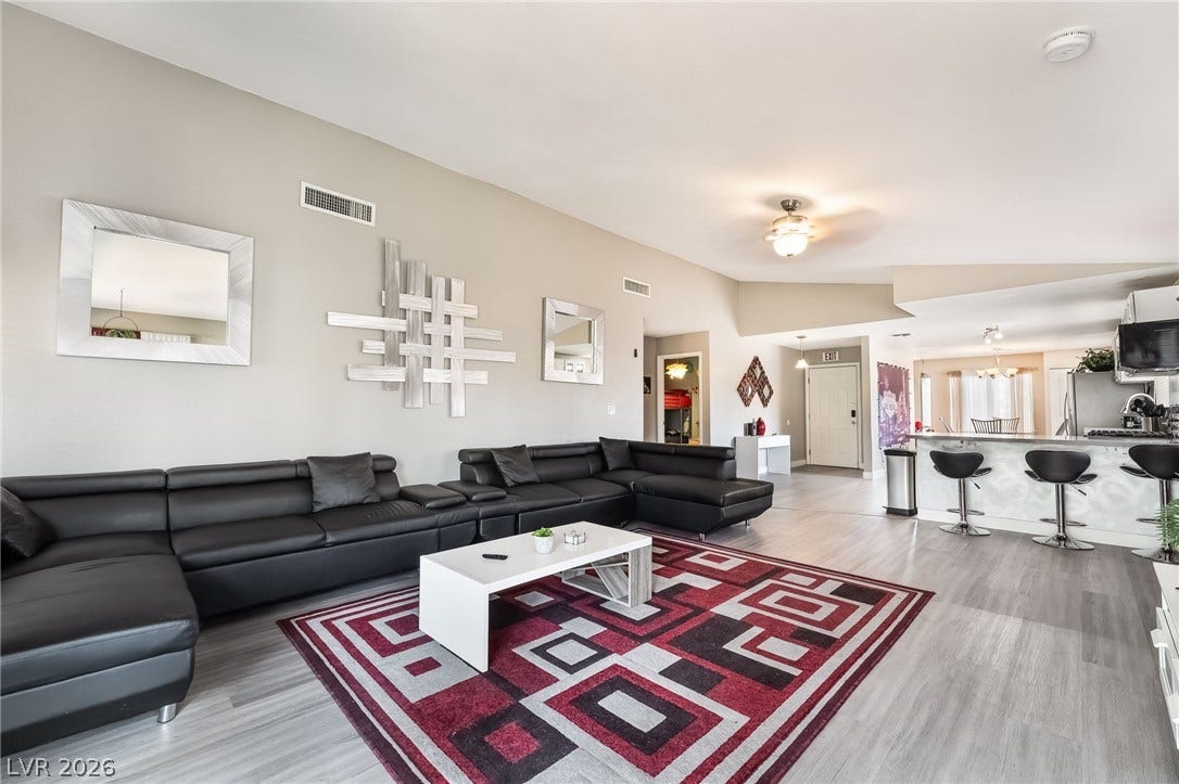 3111 Belvedere Drive, Henderson, NV 89014 An airy living room boasts high ceilings and durable vinyl plank flooring, extending into a spacious eat-in kitchen.