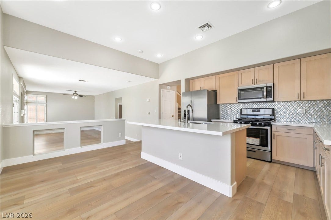1278 Autumn Wind Way, Henderson, NV 89052 A contemporary kitchen and living area feature recessed lighting and light wood flooring.