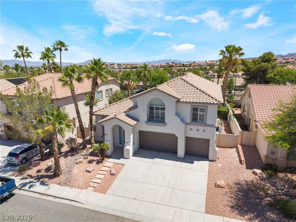 1278 Autumn Wind Way, Henderson, NV 89052 Swaying palms frame this desert oasis, offering mountain views and a welcoming stucco exterior.