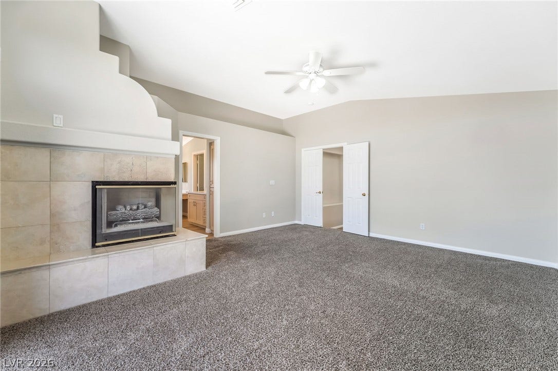 1278 Autumn Wind Way, Henderson, NV 89052 A spacious primary bedroom features a cozy fireplace and vaulted ceilings.