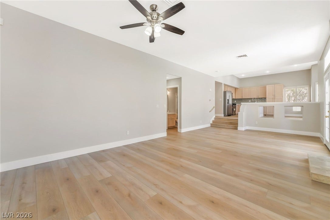 1278 Autumn Wind Way, Henderson, NV 89052 Blonde hardwood flooring and a vaulted ceiling elevate this combined living and kitchen space.