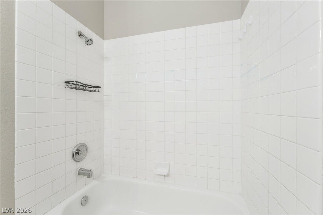 1278 Autumn Wind Way, Henderson, NV 89052 A pristine white tiled shower-tub combination awaits in this serene bathroom.