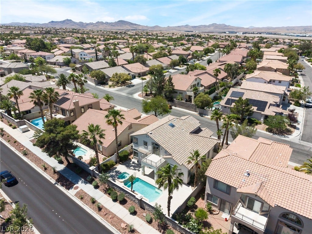 1278 Autumn Wind Way, Henderson, NV 89052 An aerial panorama reveals a well-established neighborhood with mature palm trees and private pools under a clear sky.