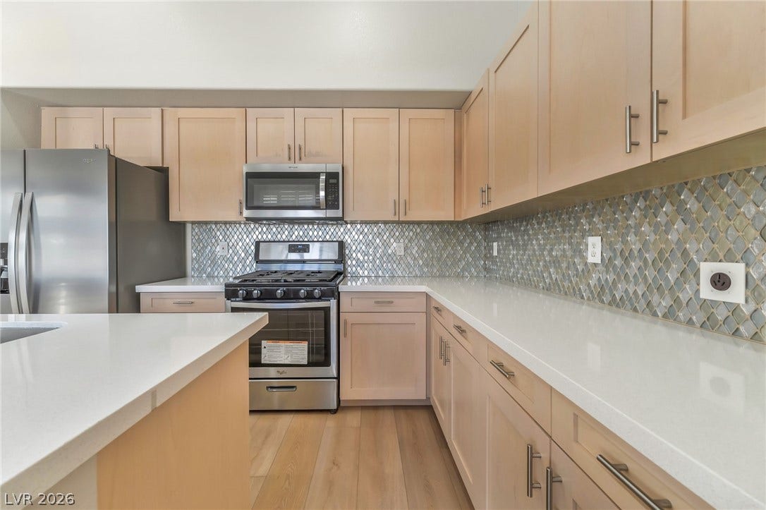 1278 Autumn Wind Way, Henderson, NV 89052 A well-appointed kitchen features stainless steel appliances, pristine counters, and warm wood flooring.