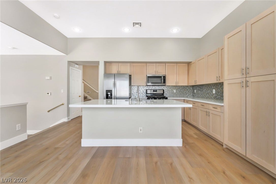 1278 Autumn Wind Way, Henderson, NV 89052 A contemporary kitchen features light wood cabinetry, sleek stainless steel appliances, and a central island.