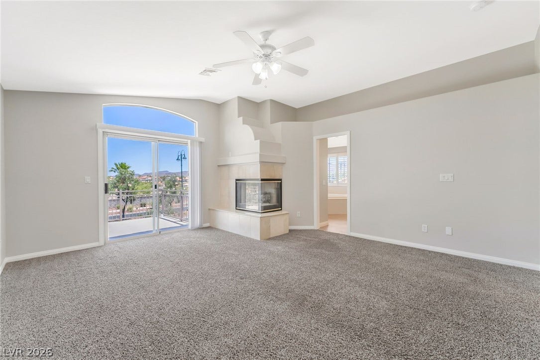 1278 Autumn Wind Way, Henderson, NV 89052 A spacious primary bedroom features a cozy corner fireplace and private balcony access.