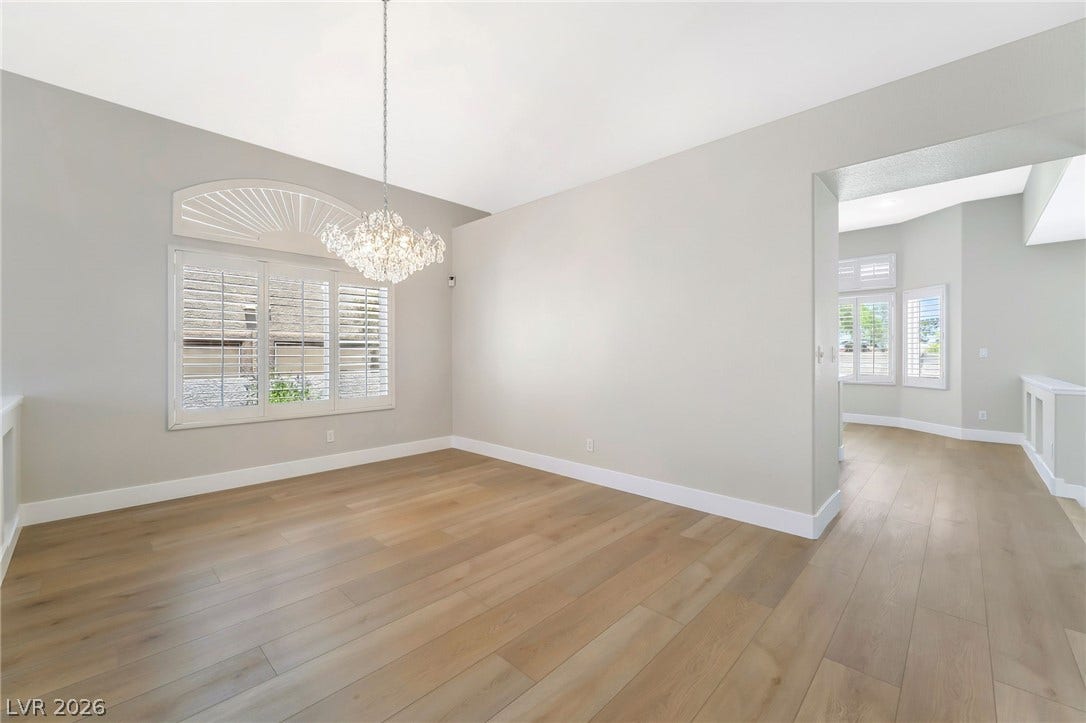 1278 Autumn Wind Way, Henderson, NV 89052 A shimmering chandelier illuminates this generously proportioned room with warm wood floors and arched window accents.