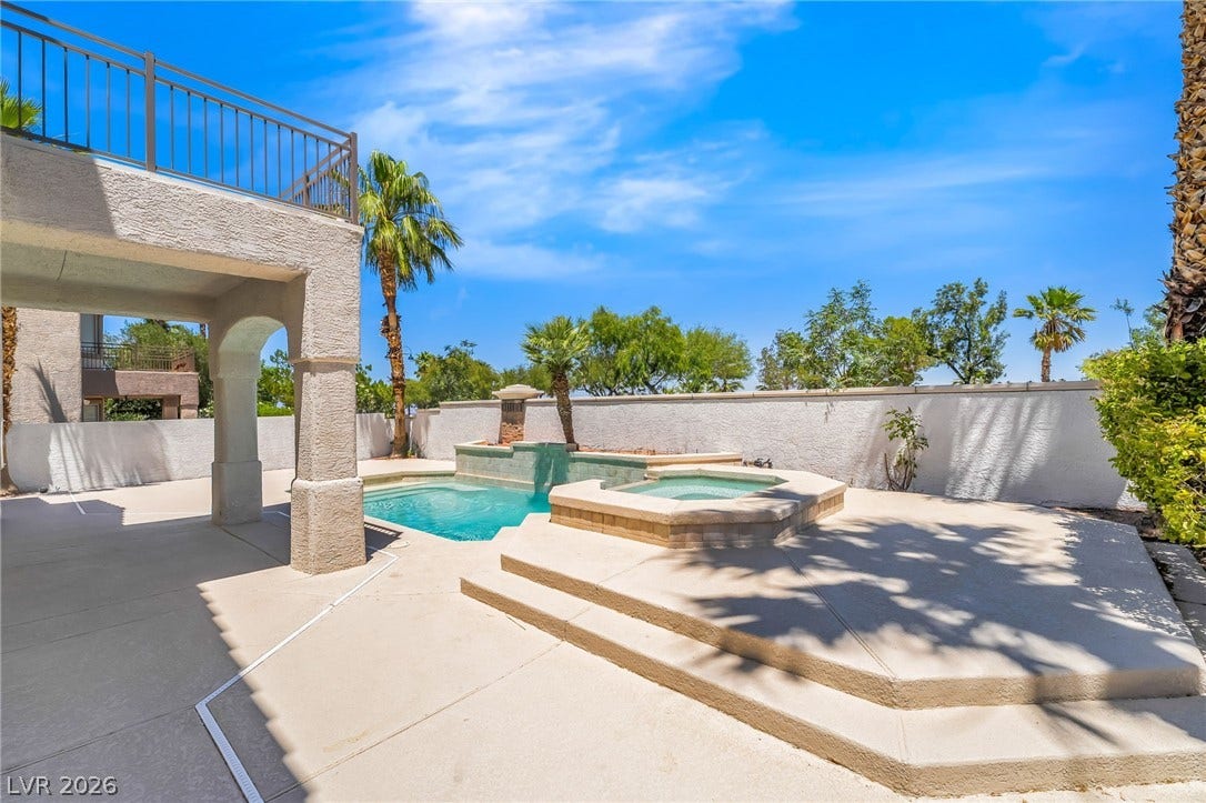 1278 Autumn Wind Way, Henderson, NV 89052 A private outdoor oasis awaits, featuring a refreshing pool, spa, and mature palm trees under a bright sky.