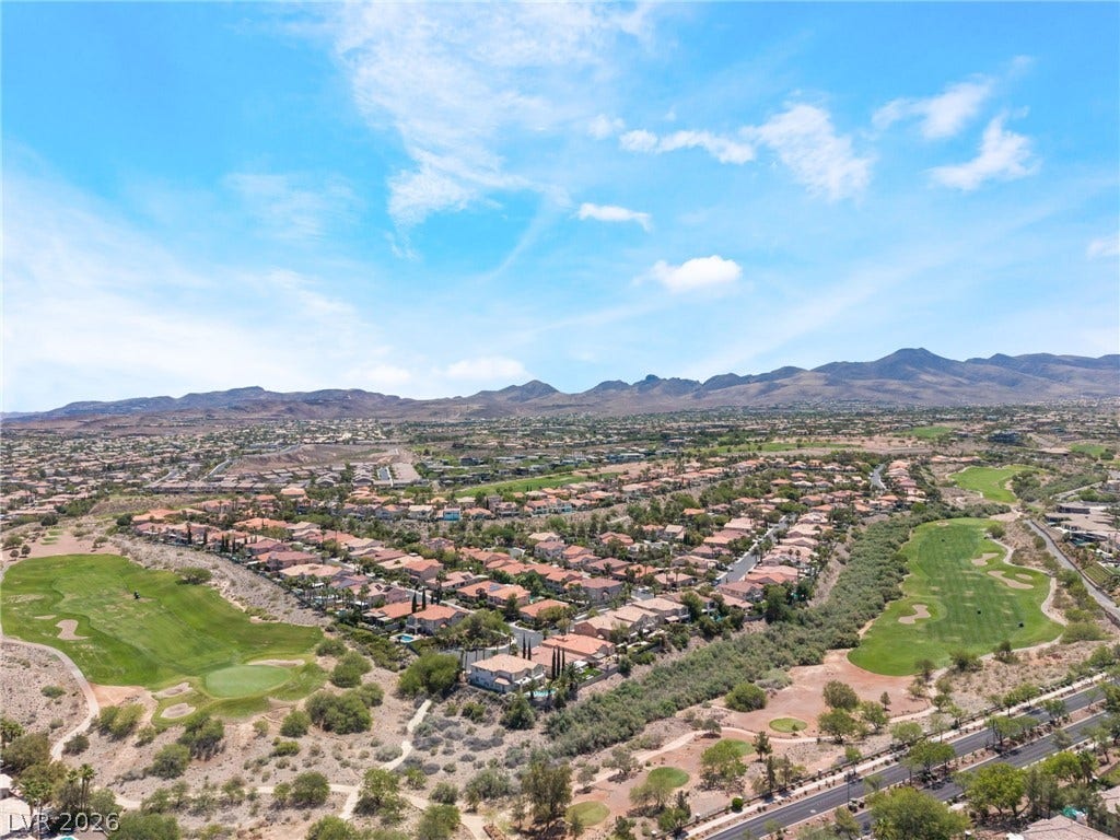 1278 Autumn Wind Way, Henderson, NV 89052 An aerial perspective reveals a vibrant community nestled between a manicured golf course and majestic mountains.