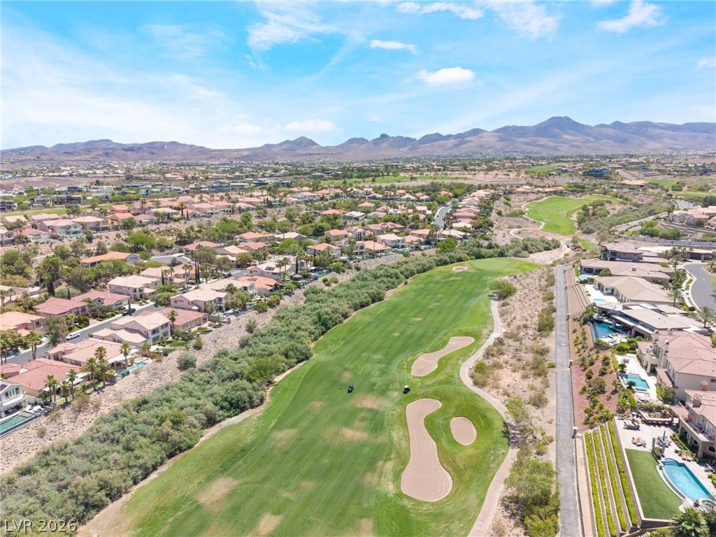 1278 Autumn Wind Way, Henderson, NV 89052 An aerial perspective reveals an expansive community seamlessly integrated with a verdant golf course, framed by distant mountains.