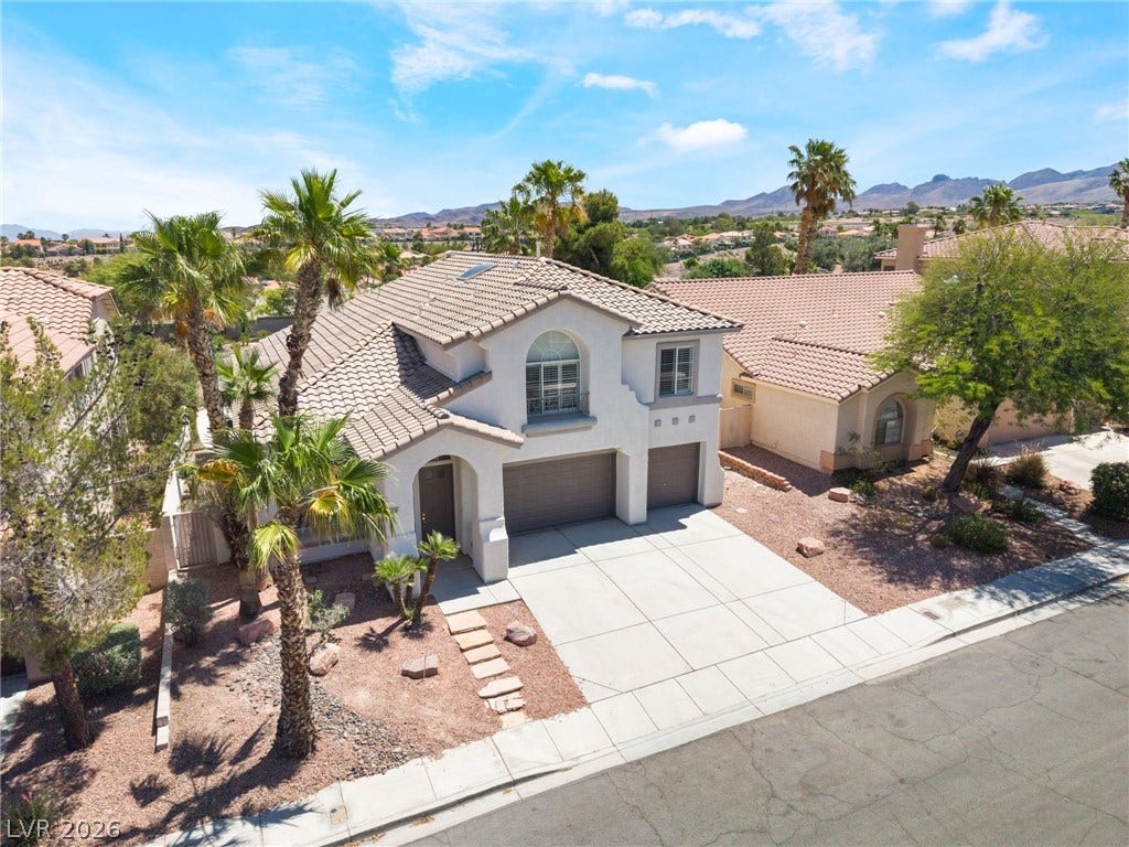 1278 Autumn Wind Way, Henderson, NV 89052 An inviting exterior with a tile roof and integrated garage, framed by palm trees and natural landscaping.