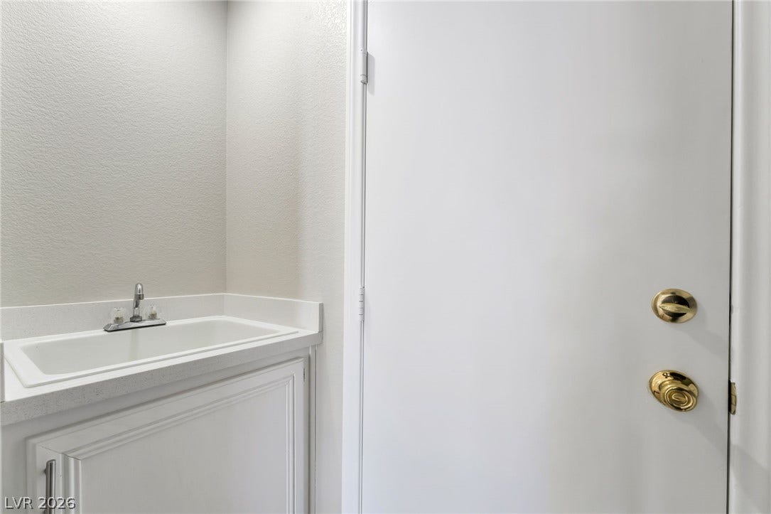 1278 Autumn Wind Way, Henderson, NV 89052 Functional utility room with a convenient washbasin and clean, classic door.