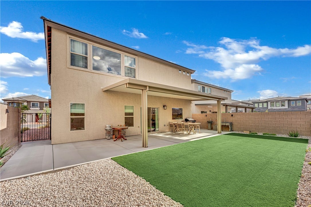 7710 Weekes Court, Las Vegas, NV 89113 A spacious covered patio overlooks a tidy lawn and gravel area under bright skies.