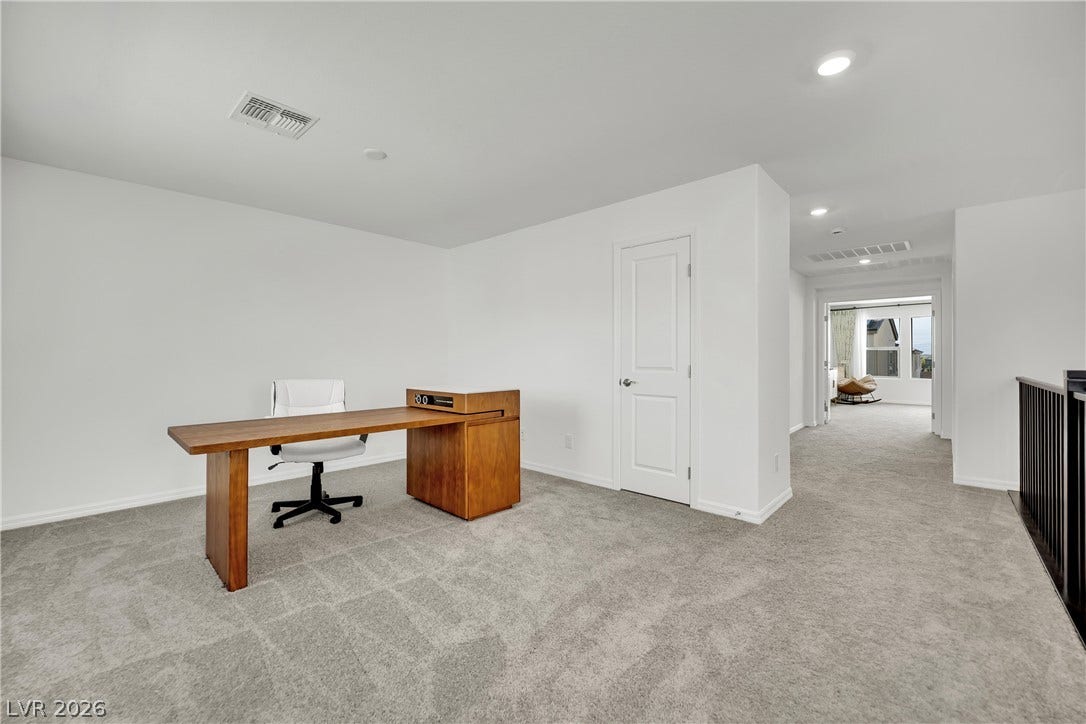 7710 Weekes Court, Las Vegas, NV 89113 Plush carpeting and recessed lighting define this versatile second-floor landing space.