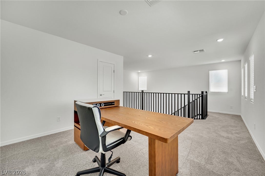 7710 Weekes Court, Las Vegas, NV 89113 Plentiful natural light and soft carpeting define this open, airy upstairs loft space.