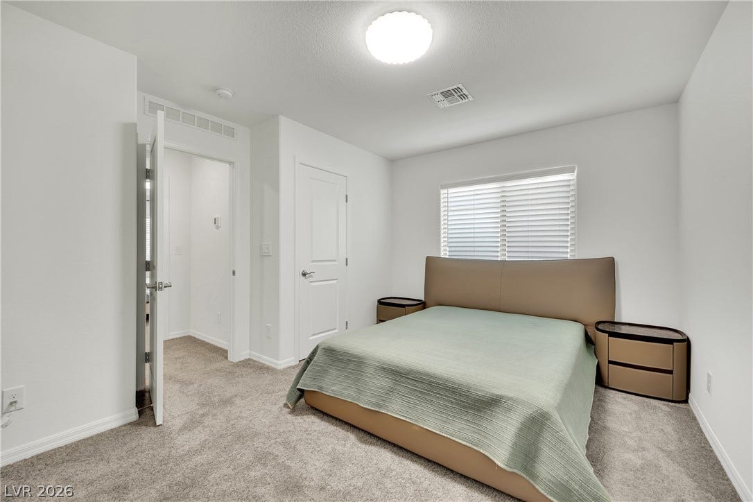 7710 Weekes Court, Las Vegas, NV 89113 Plush carpeting and natural light from a large window create a serene atmosphere.
