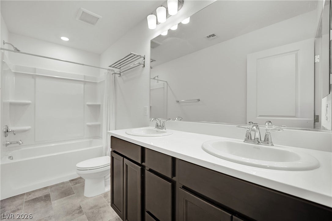 7710 Weekes Court, Las Vegas, NV 89113 A spacious double vanity and tile flooring highlight this modern bathroom.