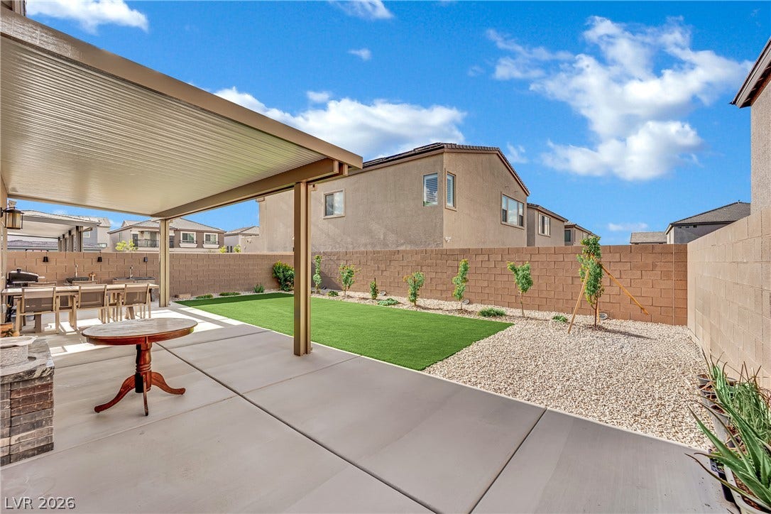 7710 Weekes Court, Las Vegas, NV 89113 A spacious concrete patio opens up to a manicured lawn enclosed by block walls.
