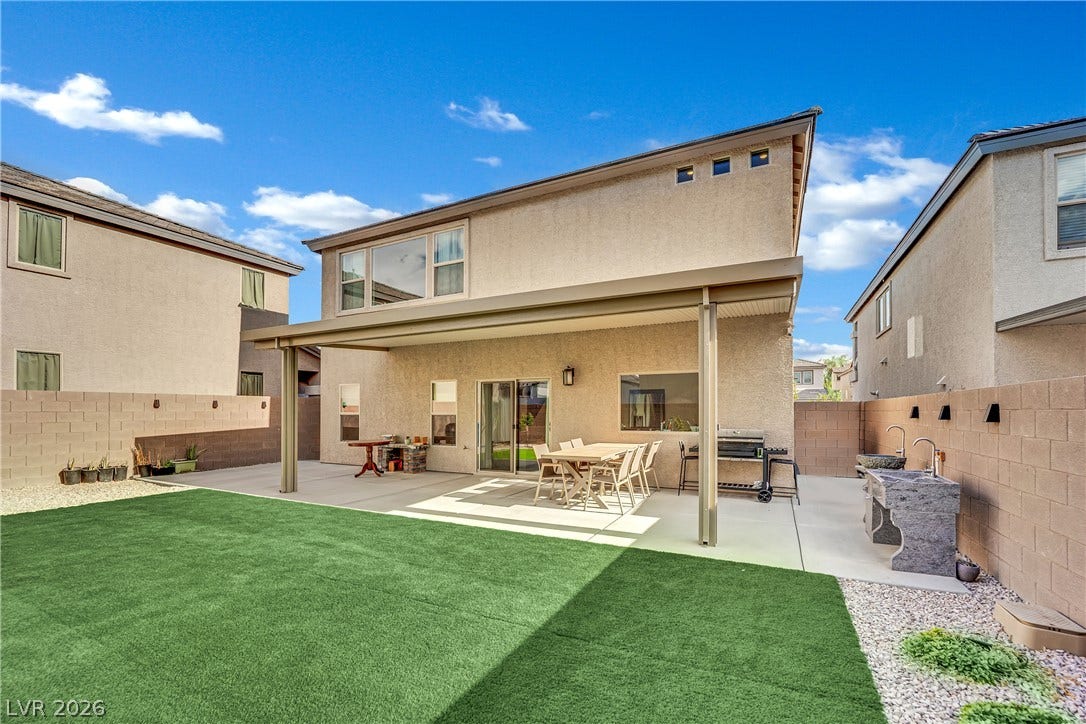 7710 Weekes Court, Las Vegas, NV 89113 A spacious covered patio overlooks the manicured green lawn in this private backyard oasis.