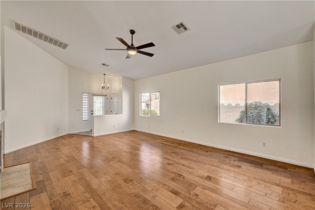 115 Cora Hills Court, Las Vegas, NV 89148 Rich hardwood floors welcome you into this spacious room, illuminated by natural light and a modern ceiling fan.